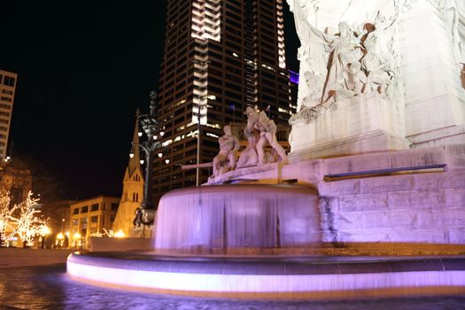 A city water fountain illuminated at night.