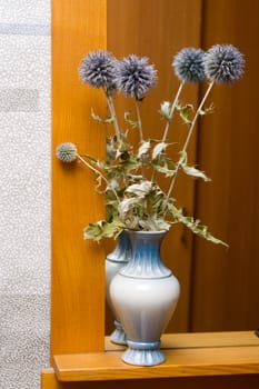 Bouquet of flowers in a vase at a mirror
