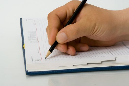 Hand writing to a notebook. Close up.