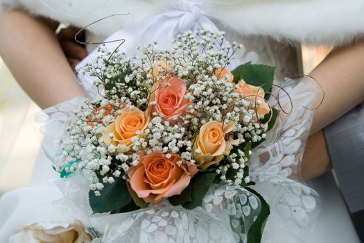 Wedding bouquet in hands of the groom and the bride