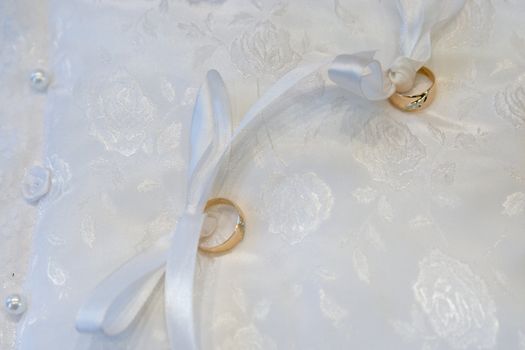 Gold wedding rings on a pillow