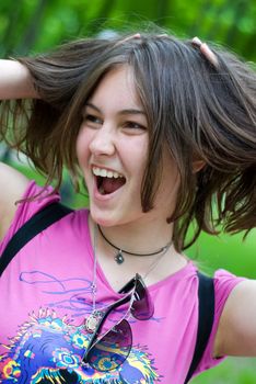 Teen girl with hands in her hair laughing