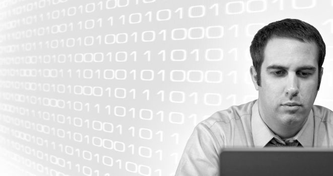 A young business man working from home on his laptop with binary code in the background.  Plenty of copy space.