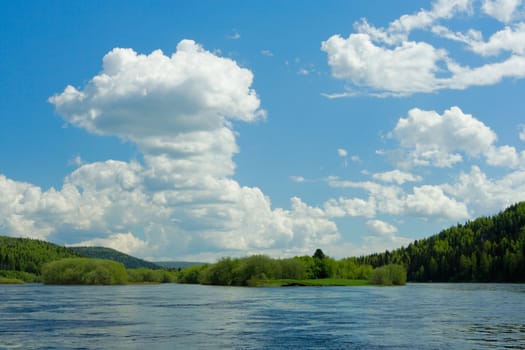 Summer landscape. Clouds above the river.