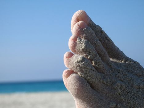 female foot covered with sand