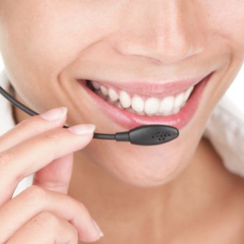 Telemarketing woman wearing headset and smiling close-up.