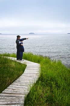 Father and son standing at Atlantic shore in Newfoundland, Canada