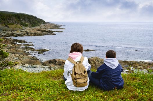 Children looking at coastal view of rocky Atlantic shore in Newfoundland, Canada