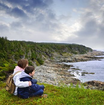 Children looking at coastal view of rocky Atlantic shore in Newfoundland, Canada