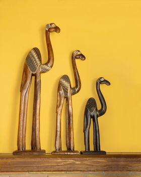 caravan of camels figures against yellow wall