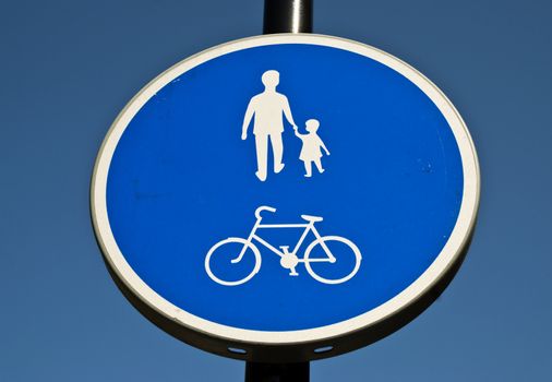 A close up of a blue and white walking and cycling sign