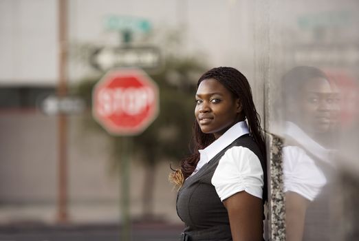 Closeup of a pretty African American woman leaning on a building