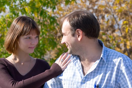 The beautiful girl and the young man in autumn park