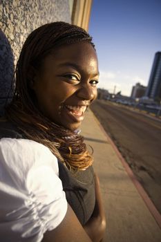 Closeup of a pretty African American woman leaning on a building