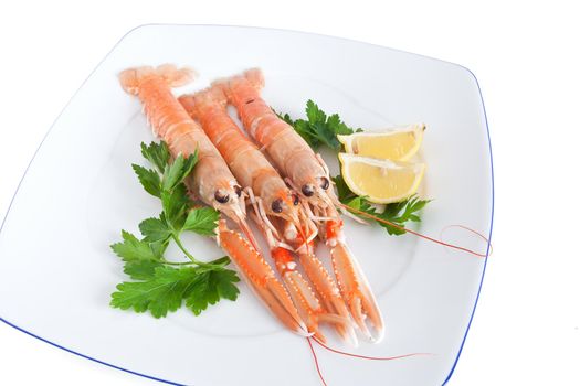 three raw prawns with lemon and parsley on a white plate isolated with clipping path