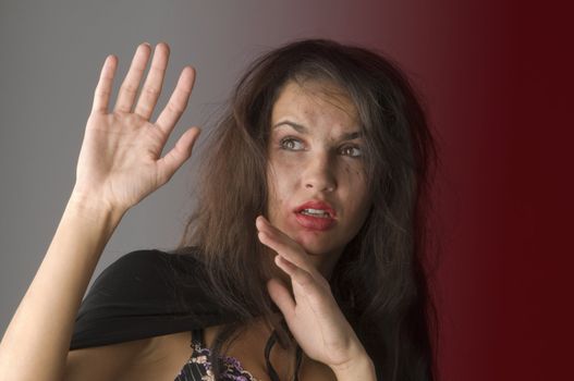 young woman in fear and keeping up hands as to defend from hit