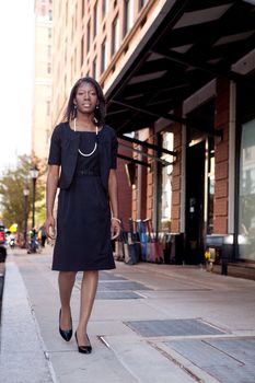 An African American business woman walking down the street