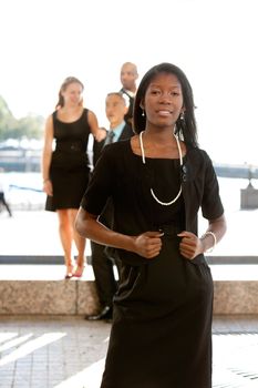 An attractive African American business woman with colleagues in the background