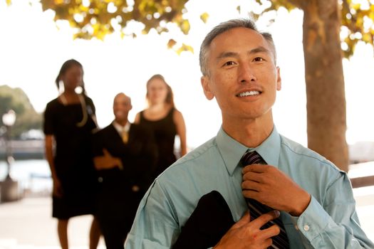 A cansual asian business man adjusting his tie