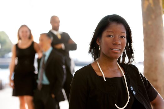 An attractive African American business woman with colleagues in the background