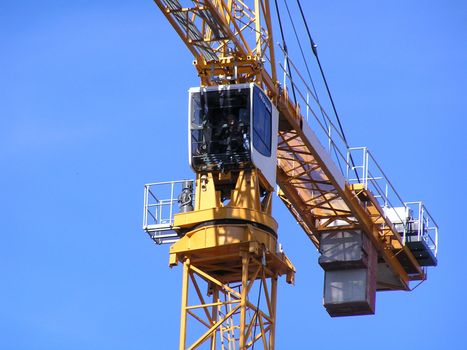 Yellow tower crane against a blue sky
