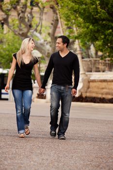 A happy couple walking in the city looking at each other