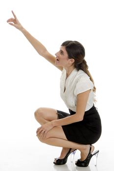 sitting lady pointing upside against white background