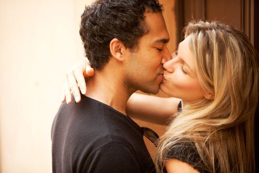 A couple kissing outdoors in an European urban setting