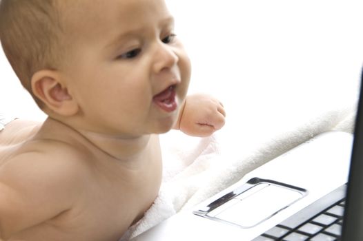 lovely curious child lying with laptop