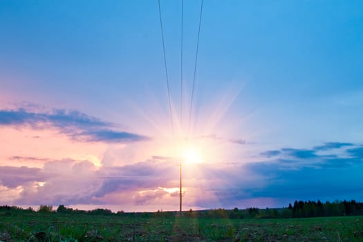 crimson dramatic sunset over the field with power line