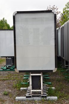 Rows of empty advertising boards stored in a backyard for later installation