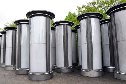 Rows of empty advertising columns stored in a backyard for later installation