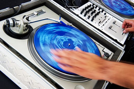 Close-up image of a DJ spinning records with motion blur