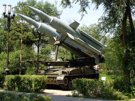 Two military rockets on a background of green trees