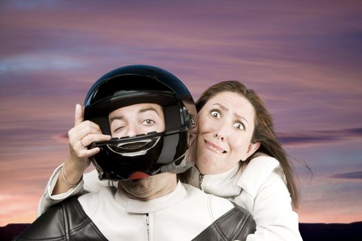 Man and fearful woman on a motorcycle in studio