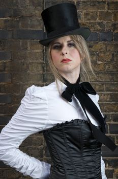 Portrait of beautiful woman in late victorian costume against brick wall