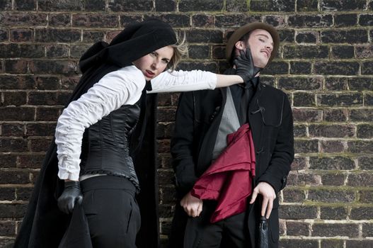 Couple in victorian costumes, woman strangling man.