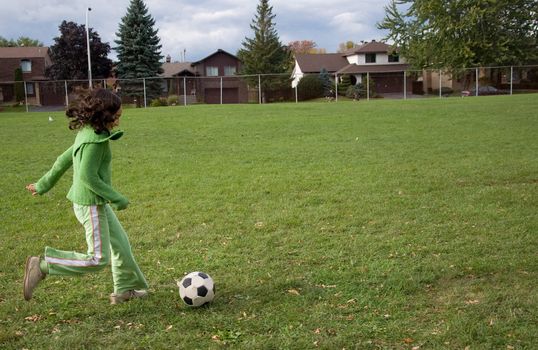 A girl kicking a soccer ball