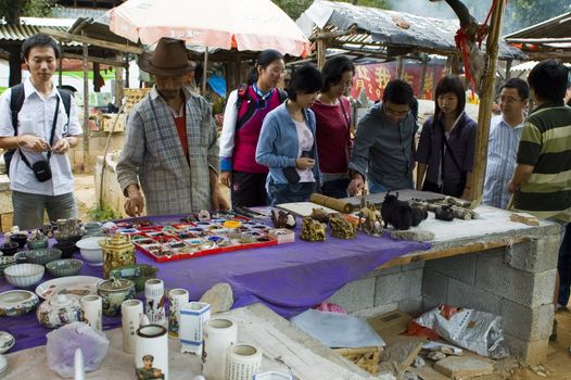 CHINA, YUNNAN PROVINCE, LIJIANG CITY - SEPTEMBER 12: minority selling traditional souvenir to Chinese tourists.