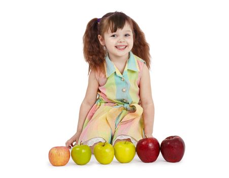 The happy child with apples of different color and the size on white