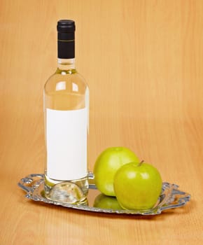 Apple wine in the closed bottle on a metal tray