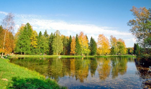 People rest near the beautiful lake in autumn day