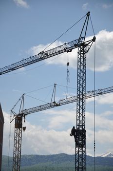 cranes on construction site with a background of blue sky 