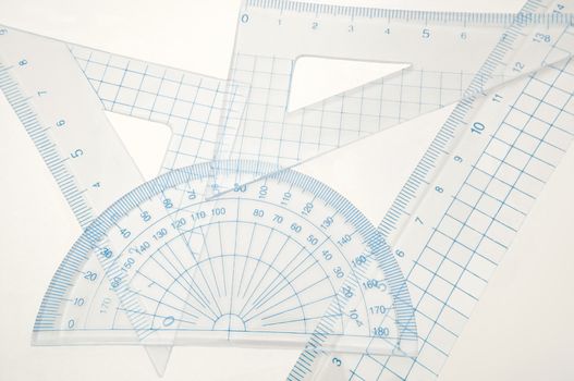 Close up of a plastic geometry set arranged over white.