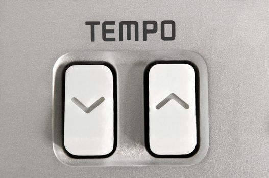 Close up of tempo control arrow buttons with the word 'tempo'.