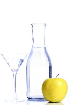 Bottle with transparent water, a glass and apples on a white background