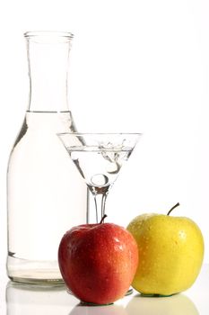 Bottle with transparent water, a glass and apples on a white background