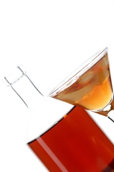 Bottle with an alcoholic drink, a glass and an orange on a white background