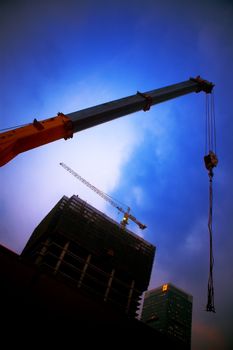 construction cranes on night ove a blue sky