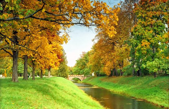 View of stone bridge, water and trees in park